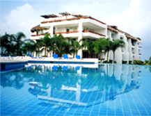 view of the condo across the beachfront infinity pool